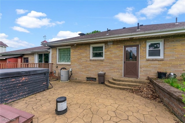 6567 Mount Everett Rd, Hubbard, OH 44425 - back of property with a hot tub, a patio, and brick siding
