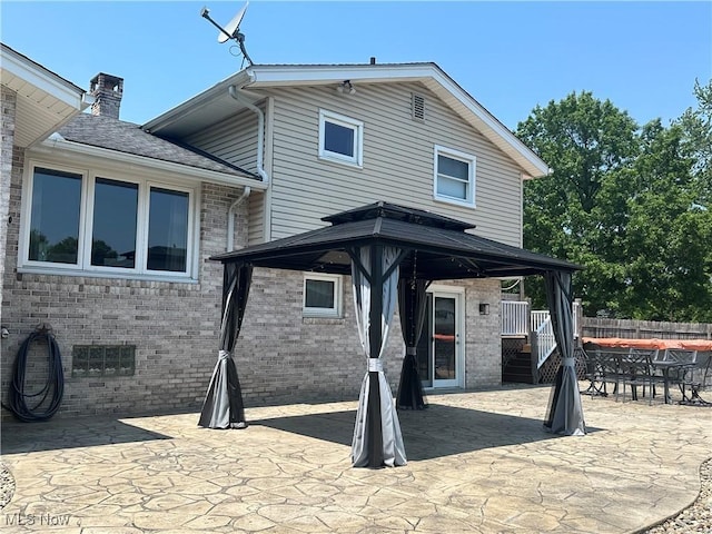 3005 Chaucer Dr NE, Canton, OH 44721 - rear view of property with brick siding, a patio, a chimney, a gazebo, and outdoor dining space