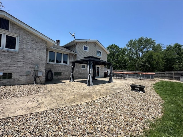 3005 Chaucer Dr NE, Canton, OH 44721 - rear view of house with a gazebo, brick siding, a patio area, and a chimney