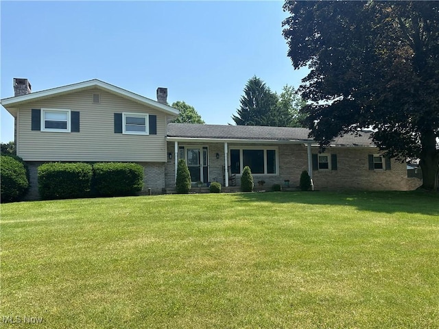 3005 Chaucer Dr NE, Canton, OH 44721 - tri-level home featuring a chimney, a front lawn, and brick siding