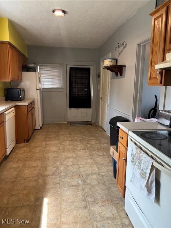 11 Front St, Rittman, OH 44270 - kitchen featuring white appliances, light countertops, brown cabinetry, and a textured ceiling