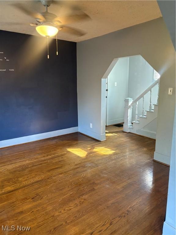 11 Front St, Rittman, OH 44270 - unfurnished living room featuring wood finished floors, ceiling fan, and stairway