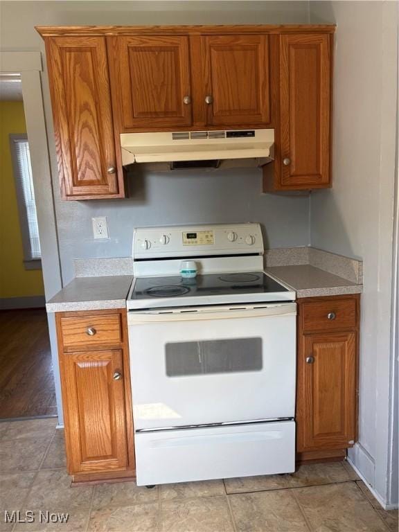 11 Front St, Rittman, OH 44270 - kitchen featuring white electric range, under cabinet range hood, brown cabinetry, and light countertops