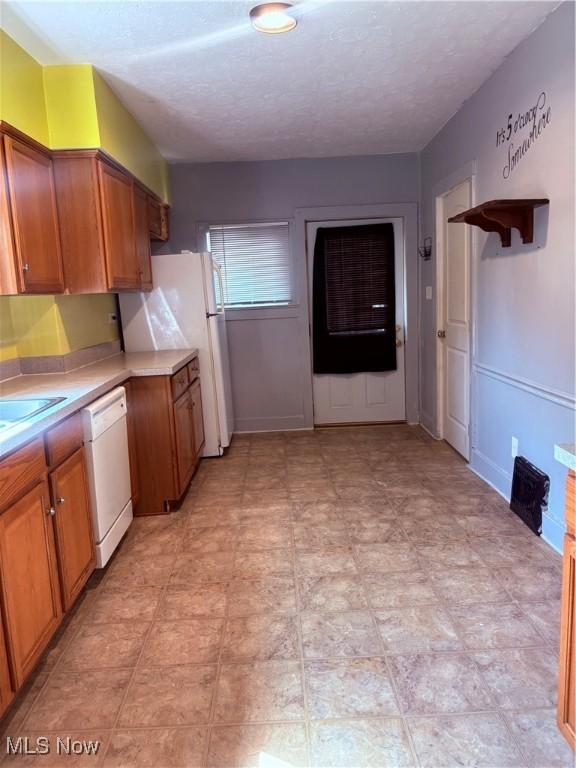 11 Front St, Rittman, OH 44270 - kitchen with white appliances, light countertops, brown cabinets, and a textured ceiling