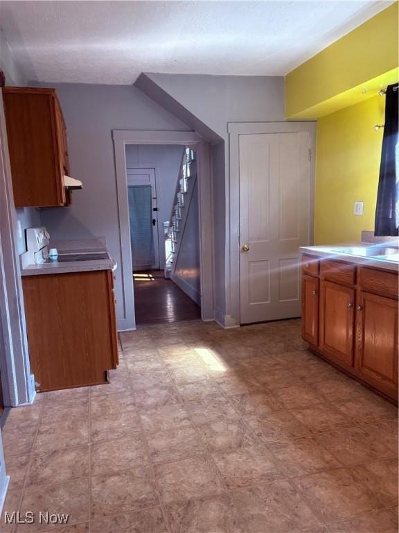 11 Front St, Rittman, OH 44270 - kitchen featuring brown cabinetry, light countertops, ventilation hood, and range