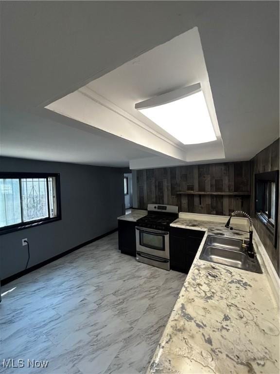 3351 E 65th St, Cleveland, OH 44127 - kitchen with gas range, dark cabinetry, light countertops, and wood walls