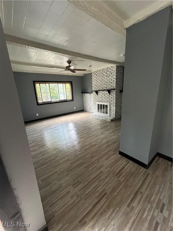 3351 E 65th St, Cleveland, OH 44127 - unfurnished living room with wood finished floors, ceiling fan, beamed ceiling, and a fireplace