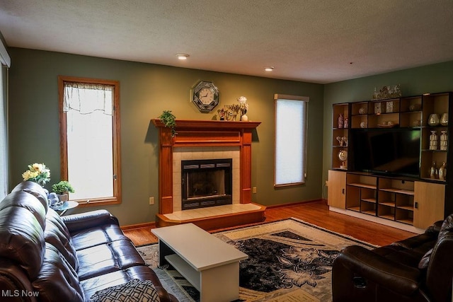 620 Ridgeline Dr, Cuyahoga Falls, OH 44223 - living area with a tiled fireplace, plenty of natural light, wood finished floors, and a textured ceiling