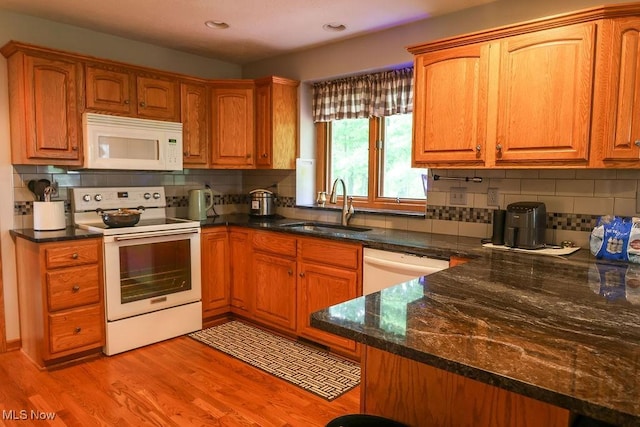 620 Ridgeline Dr, Cuyahoga Falls, OH 44223 - kitchen featuring white appliances, backsplash, light wood finished floors, dark stone countertops, and brown cabinets