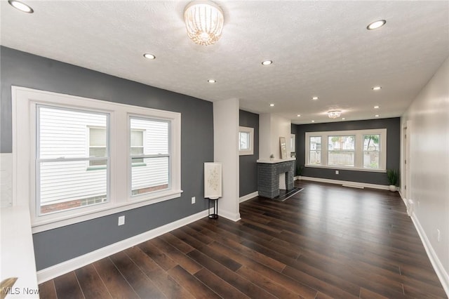 10310 Thrush Ave, Cleveland, OH 44111 - unfurnished living room with recessed lighting, dark wood-type flooring, a fireplace, and a textured ceiling