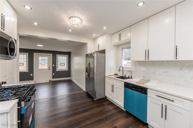 10310 Thrush Ave, Cleveland, OH 44111 - kitchen featuring appliances with stainless steel finishes, decorative backsplash, dark wood-type flooring, light countertops, and recessed lighting