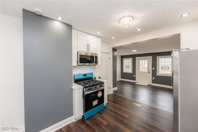 10310 Thrush Ave, Cleveland, OH 44111 - kitchen with appliances with stainless steel finishes, white cabinetry, dark wood-style floors, a textured ceiling, and recessed lighting