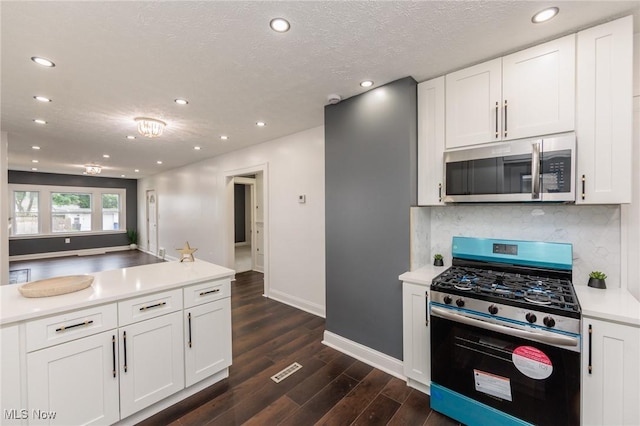 10310 Thrush Ave, Cleveland, OH 44111 - kitchen featuring stainless steel appliances, recessed lighting, dark wood-style floors, backsplash, and white cabinetry