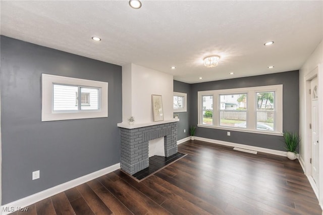 10310 Thrush Ave, Cleveland, OH 44111 - unfurnished living room with wood finished floors, recessed lighting, and a brick fireplace