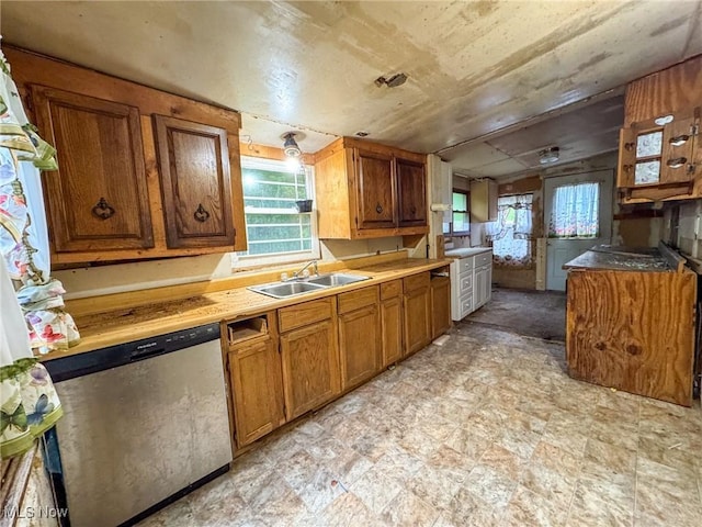 5477 Dueber Ave, East Sparta, OH 44626 - kitchen featuring stainless steel dishwasher, brown cabinetry, plenty of natural light, vaulted ceiling, and light countertops