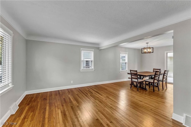 6207 Dartworth Dr, Parma, OH 44129 - dining area with a chandelier, wood-type flooring, and a textured ceiling