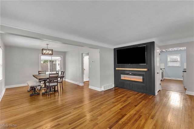 6207 Dartworth Dr, Parma, OH 44129 - dining area with a large fireplace, wood finished floors, and a chandelier