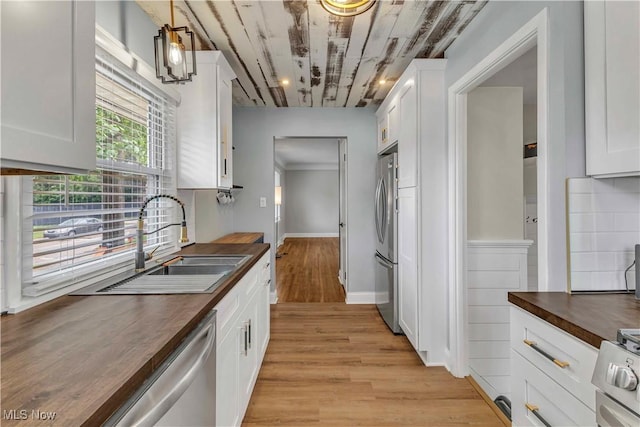 6207 Dartworth Dr, Parma, OH 44129 - kitchen featuring wood counters, stainless steel appliances, white cabinetry, light wood-type flooring, and tasteful backsplash