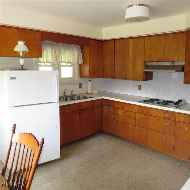 399 N Main St, Amsterdam, OH 43903 - kitchen featuring freestanding refrigerator, under cabinet range hood, stainless steel gas cooktop, and brown cabinetry