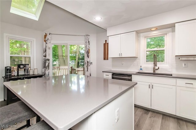 5710 Cardinal Dr, Mentor, OH 44060 - kitchen featuring stainless steel dishwasher, light wood-style floors, a breakfast bar, backsplash, and recessed lighting