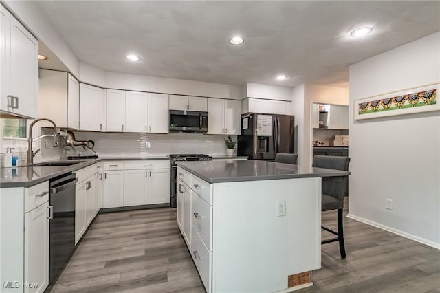 5710 Cardinal Dr, Mentor, OH 44060 - kitchen featuring appliances with stainless steel finishes, backsplash, a kitchen bar, a kitchen island, and recessed lighting
