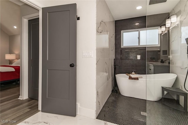 5710 Cardinal Dr, Mentor, OH 44060 - full bathroom with a freestanding bath, ensuite bathroom, vanity, tile walls, and marble finish flooring