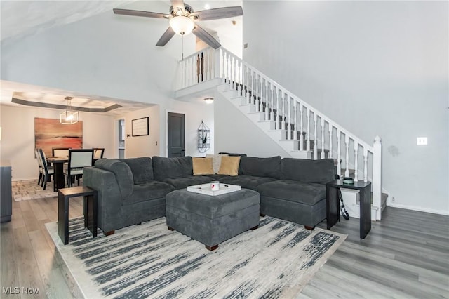5710 Cardinal Dr, Mentor, OH 44060 - living room featuring wood finished floors, stairway, a high ceiling, and ceiling fan