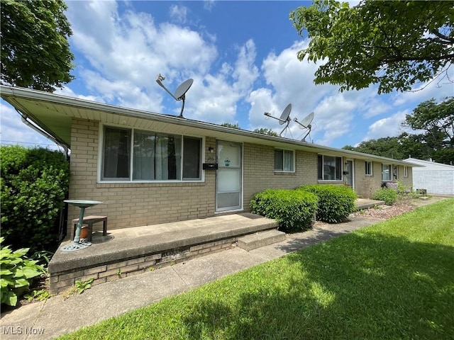 233 Kennedy St, Louisville, OH 44641 - view of front of house featuring brick siding and a front yard