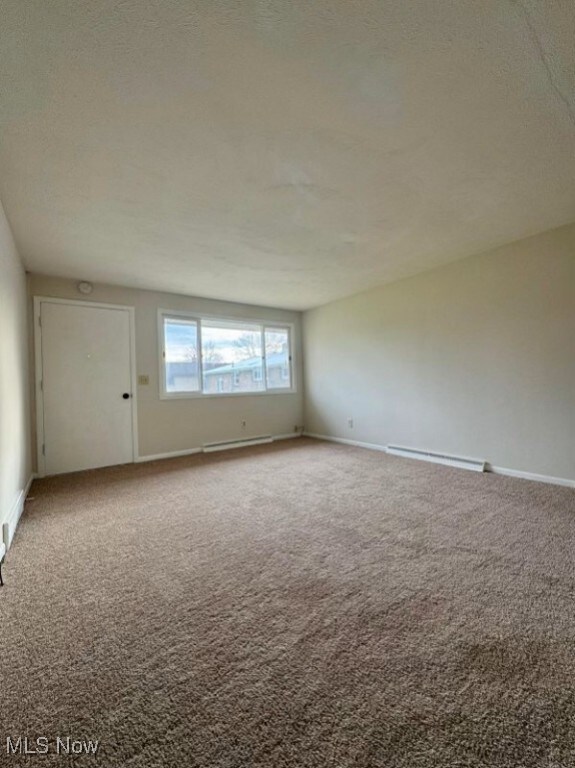 233 Kennedy St, Louisville, OH 44641 - unfurnished room with carpet flooring and a baseboard radiator