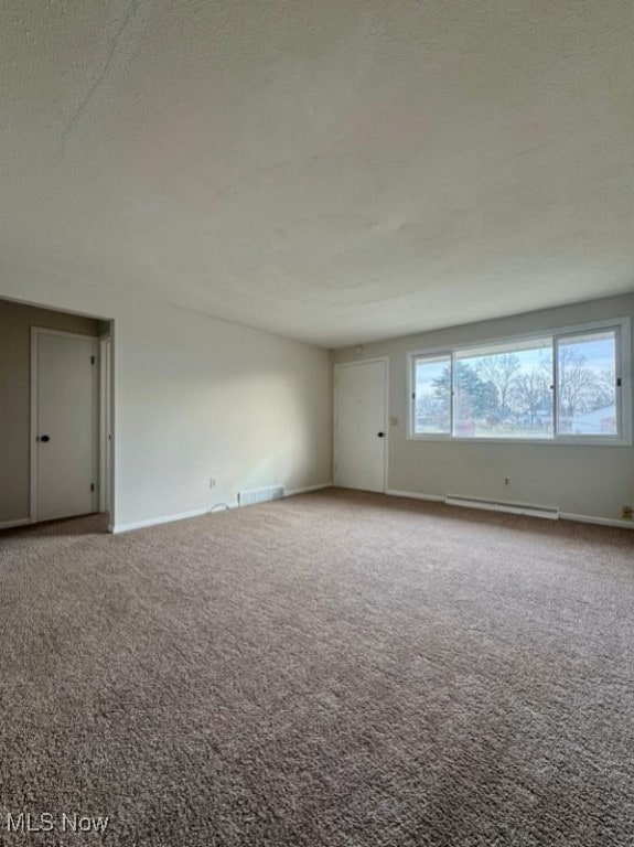 233 Kennedy St, Louisville, OH 44641 - carpeted empty room featuring a baseboard heating unit and a textured ceiling