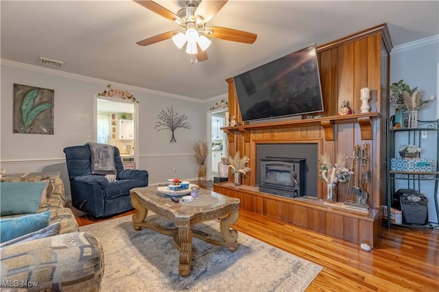 1201 Overlook Dr, Alliance, OH 44601 - living room with wood finished floors, a fireplace with raised hearth, ceiling fan, and ornamental molding