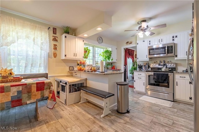 1201 Overlook Dr, Alliance, OH 44601 - kitchen with appliances with stainless steel finishes, light wood-style flooring, white cabinetry, a ceiling fan, and recessed lighting