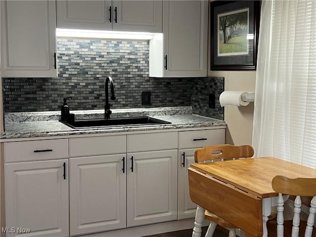 1749 Highview Ave, Akron, OH 44301 - kitchen featuring backsplash, white cabinets, and light stone counters