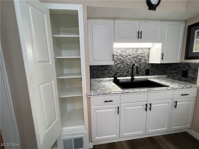1749 Highview Ave, Akron, OH 44301 - kitchen with white cabinets, light stone counters, dark wood finished floors, and backsplash