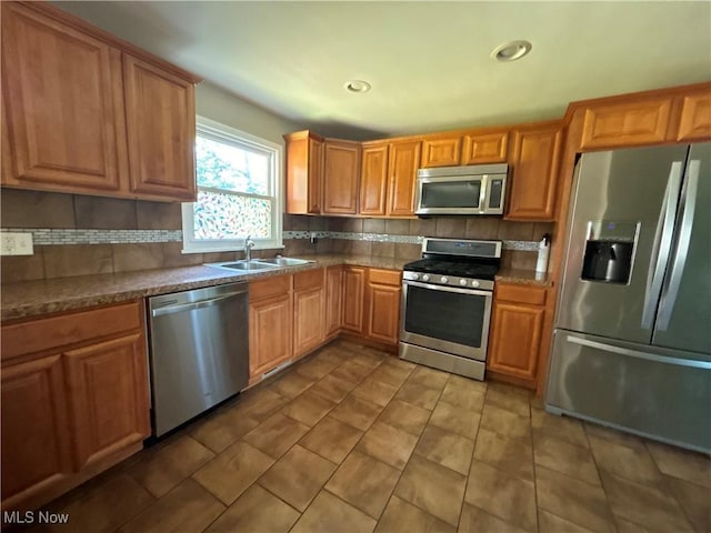 1312 Glennview St NE, Canton, OH 44721 - kitchen featuring appliances with stainless steel finishes, decorative backsplash, tile patterned flooring, recessed lighting, and brown cabinetry