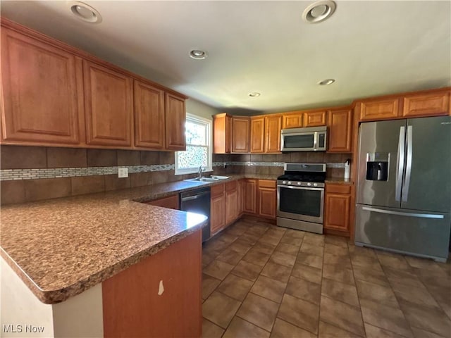 1312 Glennview St NE, Canton, OH 44721 - kitchen featuring stainless steel appliances, decorative backsplash, tile patterned flooring, brown cabinets, and recessed lighting