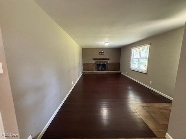 1312 Glennview St NE, Canton, OH 44721 - unfurnished living room with a fireplace with raised hearth and dark wood-type flooring