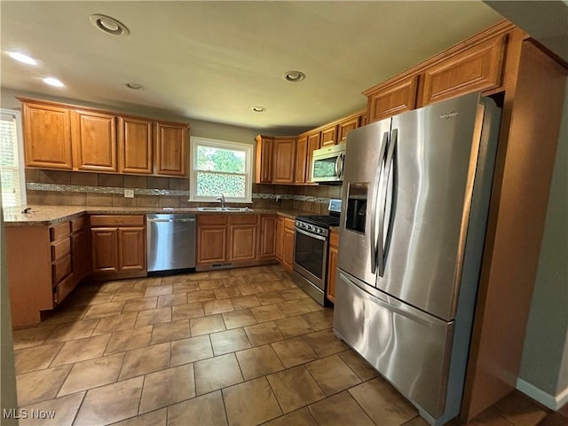 1312 Glennview St NE, Canton, OH 44721 - kitchen featuring stainless steel appliances, decorative backsplash, brown cabinets, recessed lighting, and dark stone counters