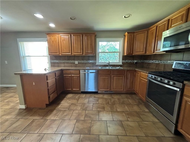 1312 Glennview St NE, Canton, OH 44721 - kitchen featuring stainless steel appliances, a peninsula, tasteful backsplash, recessed lighting, and brown cabinets