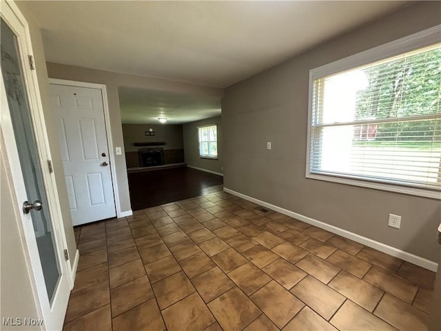 1312 Glennview St NE, Canton, OH 44721 - unfurnished room with a fireplace and dark tile patterned floors