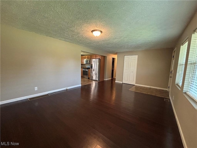 1312 Glennview St NE, Canton, OH 44721 - spare room featuring dark wood-type flooring and a textured ceiling
