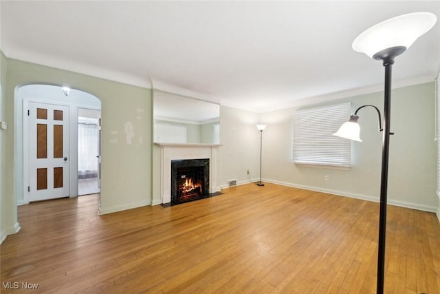 16200 Elsienna Ave, Cleveland, OH 44135 - unfurnished living room featuring light wood-type flooring, a fireplace with flush hearth, and arched walkways