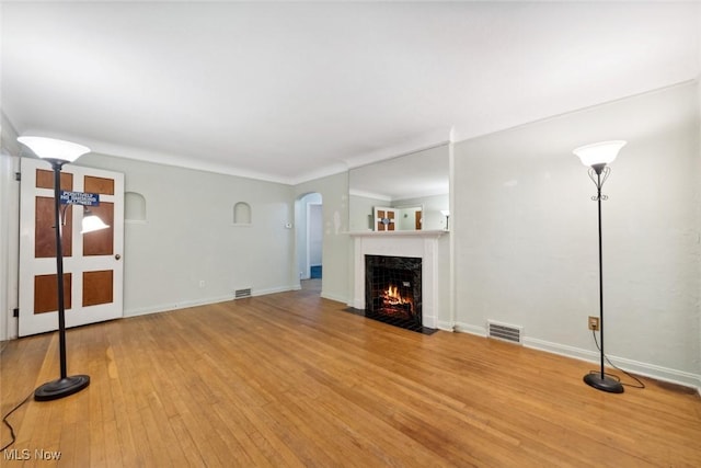 16200 Elsienna Ave, Cleveland, OH 44135 - unfurnished living room featuring wood finished floors, a fireplace with flush hearth, and arched walkways