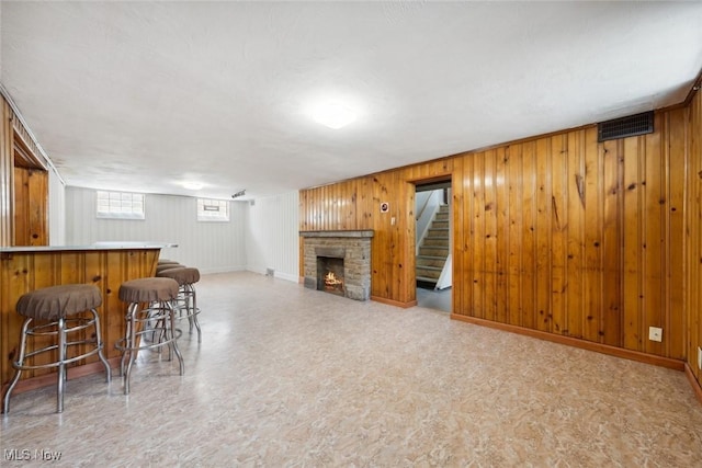 16200 Elsienna Ave, Cleveland, OH 44135 - living room with a bar, wooden walls, stairway, and a brick fireplace