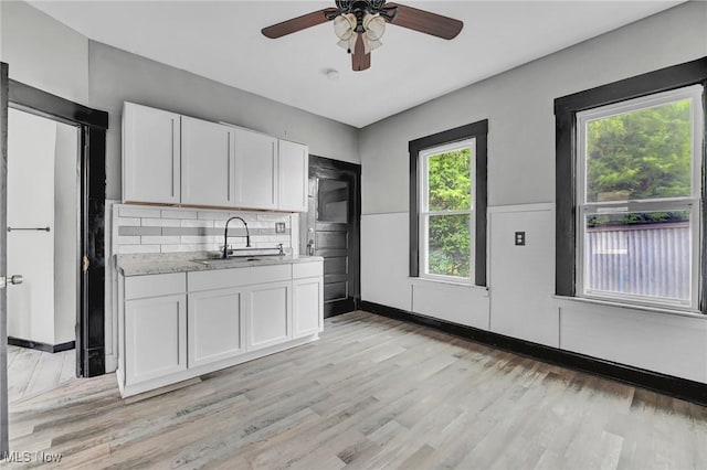 3620 E 63rd St, Cleveland, OH 44105 - kitchen featuring white cabinetry, a ceiling fan, light wood-style floors, and tasteful backsplash