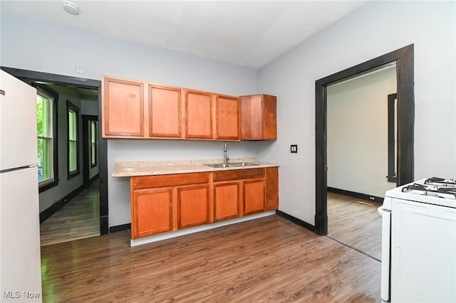 3620 E 63rd St, Cleveland, OH 44105 - kitchen featuring white appliances, light countertops, dark wood-style flooring, and brown cabinets