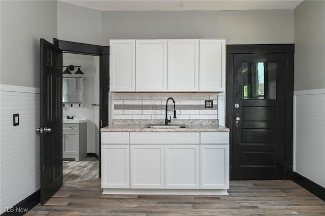 3620 E 63rd St, Cleveland, OH 44105 - kitchen featuring wood finished floors, white cabinetry, light countertops, tasteful backsplash, and wainscoting