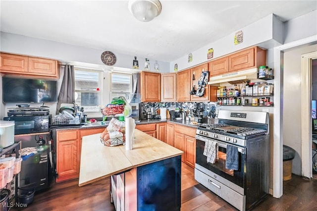 3676 E 69th St, Cleveland, OH 44105 - kitchen with gas range, under cabinet range hood, dark wood finished floors, a kitchen island, and decorative backsplash