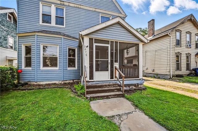3676 E 69th St, Cleveland, OH 44105 - view of front of property with a front yard and a sunroom