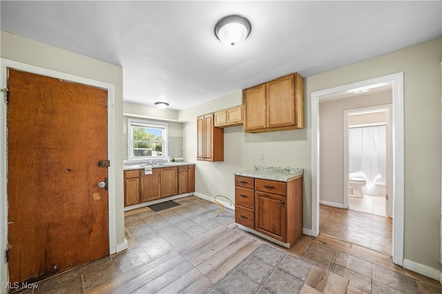 1369 Adelaide Ave SE, Warren, OH 44484 - kitchen with baseboards and brown cabinetry
